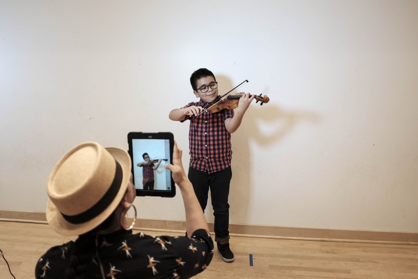UCLA Mentor photographing JB Arts Student portrait using iPad camera.