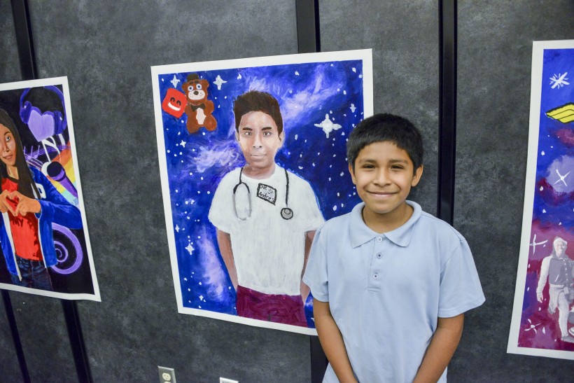 JB Arts Student and his final self-portrait on display at the end of the year assembly.