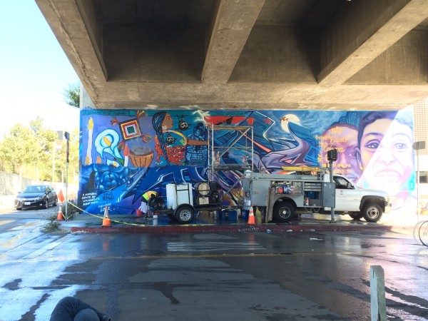 Mural painted over, with left side of La Ofrenda starting to peak through SPARC's MuralShield Process.