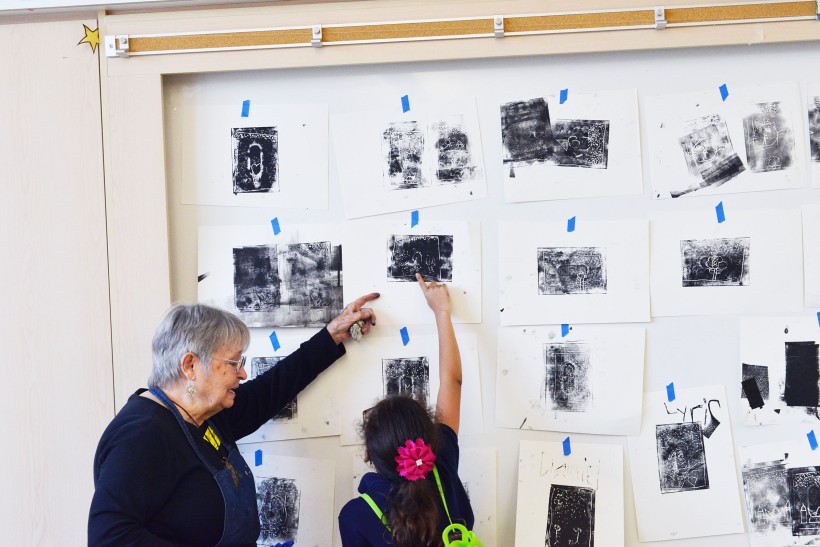 Teaching Artist, Kay Brown, and 2nd grade student from Ms. Serratos’ class discuss their final prints after a printmaking workshop.